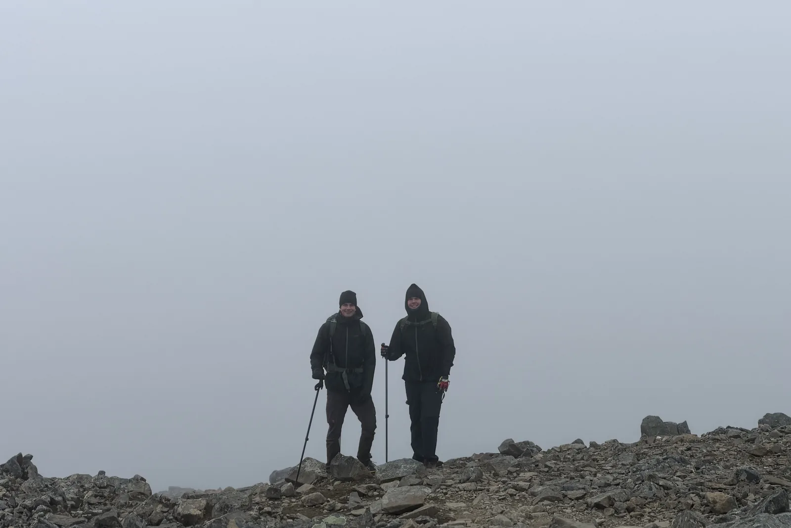 Standing on a foggy mountain summit with a friend